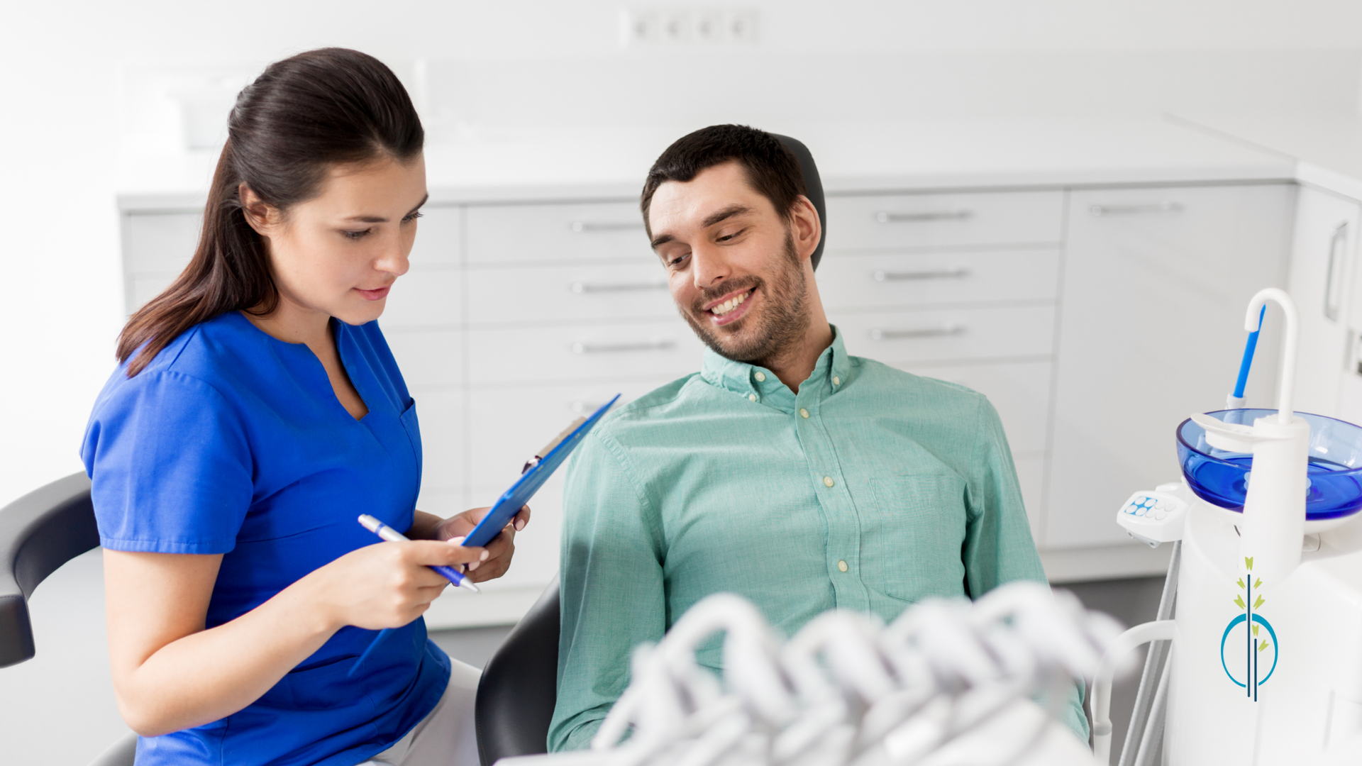 A dentist is talking to a patient in a dental chair.