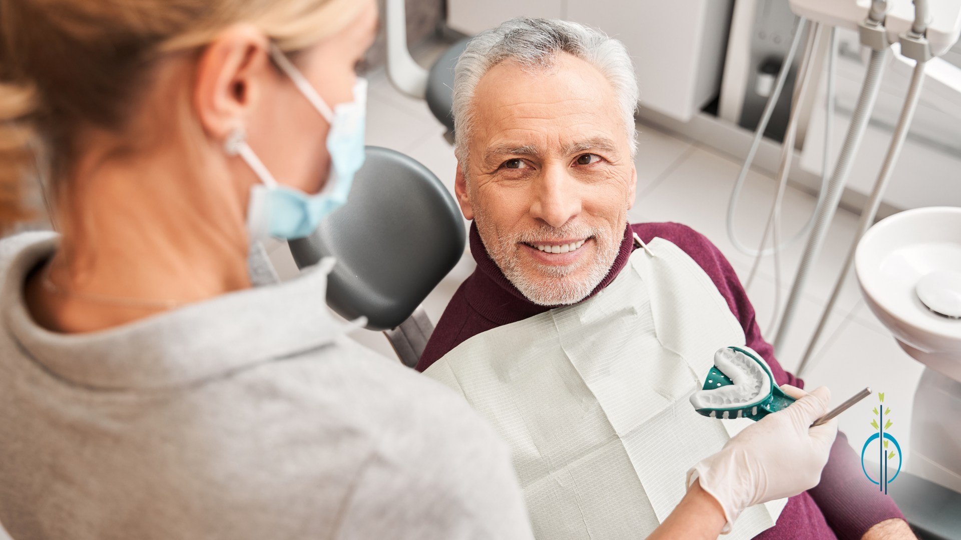 A man is sitting in a dental chair while a dentist examines his teeth.