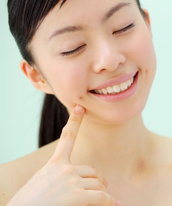 A woman in a blue shirt is smiling for the camera.
