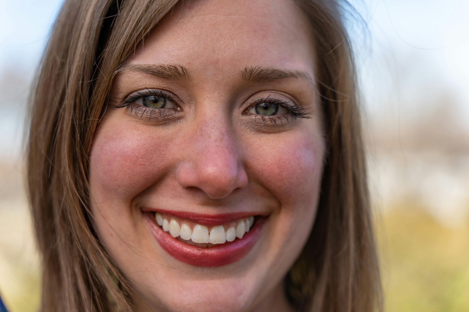 A close up of a woman 's face smiling.