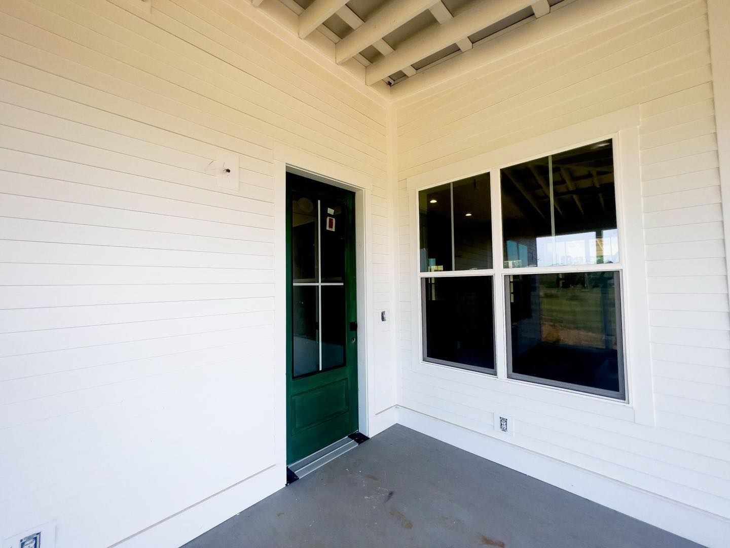 A white house with a green door and windows