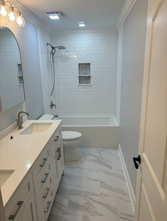 A bathroom with a sink , toilet , tub and mirror.