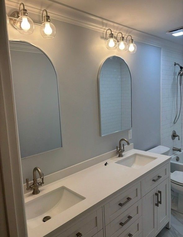 A bathroom with two sinks and two mirrors.
