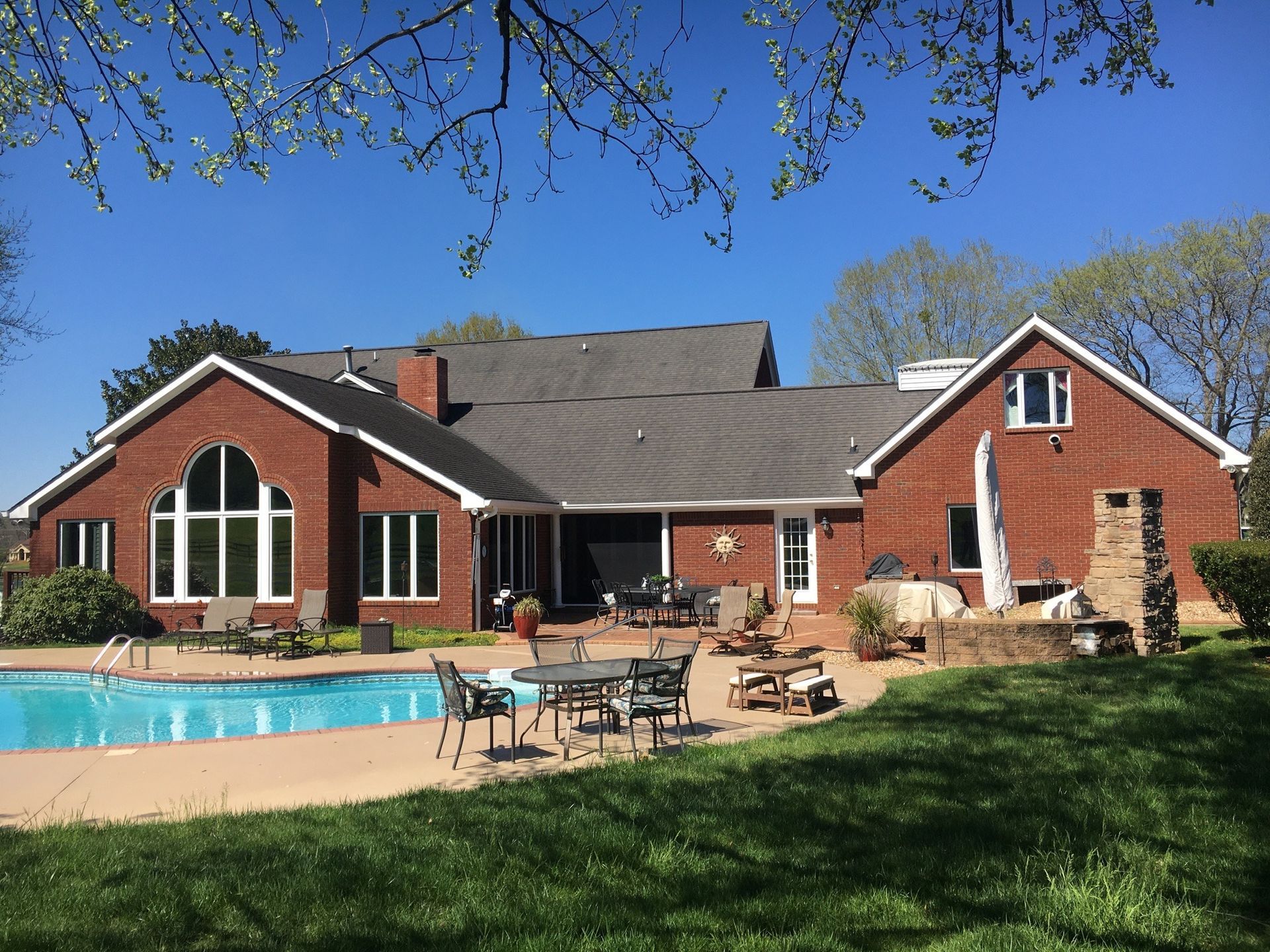 A large brick house with a swimming pool in the backyard