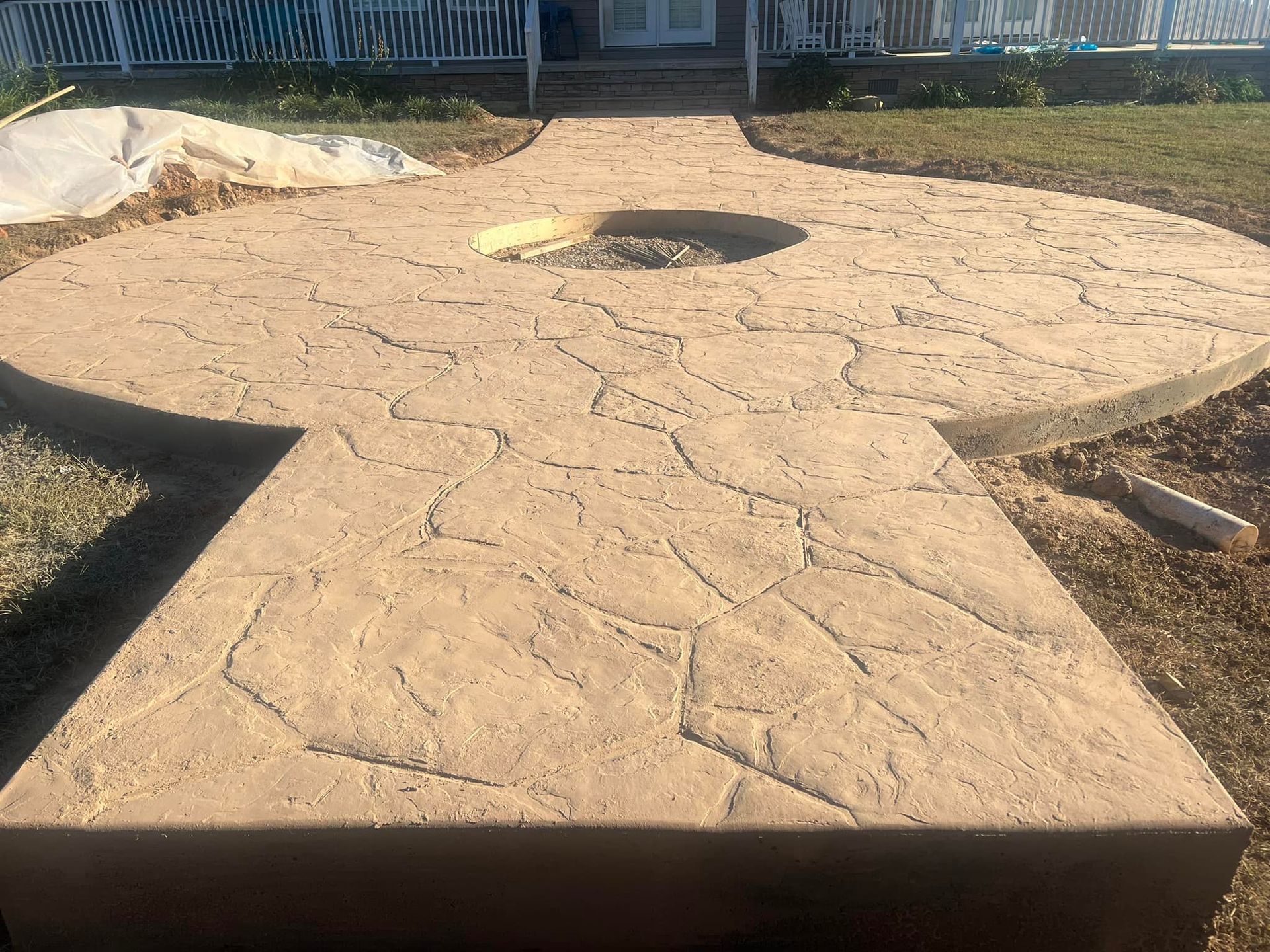 A concrete walkway with a fire pit in the middle of it.