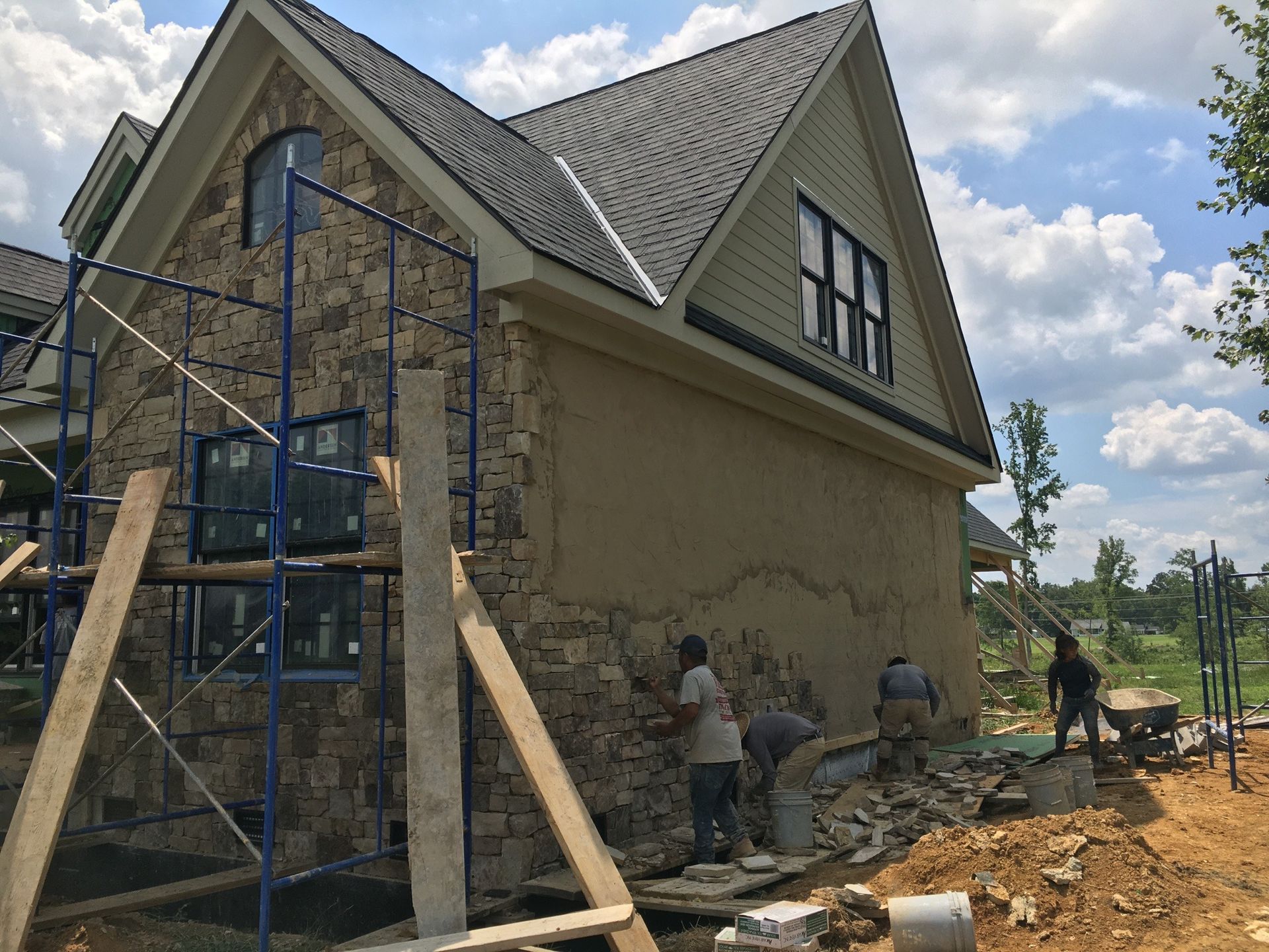 A house under construction with a pile of dirt in front of it