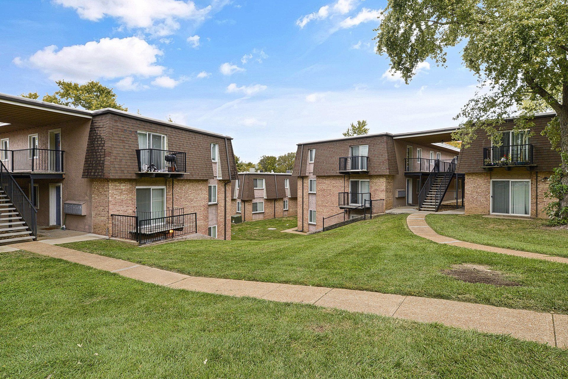 Exterior of Westport Crossing Apartments with large grass area and walkway