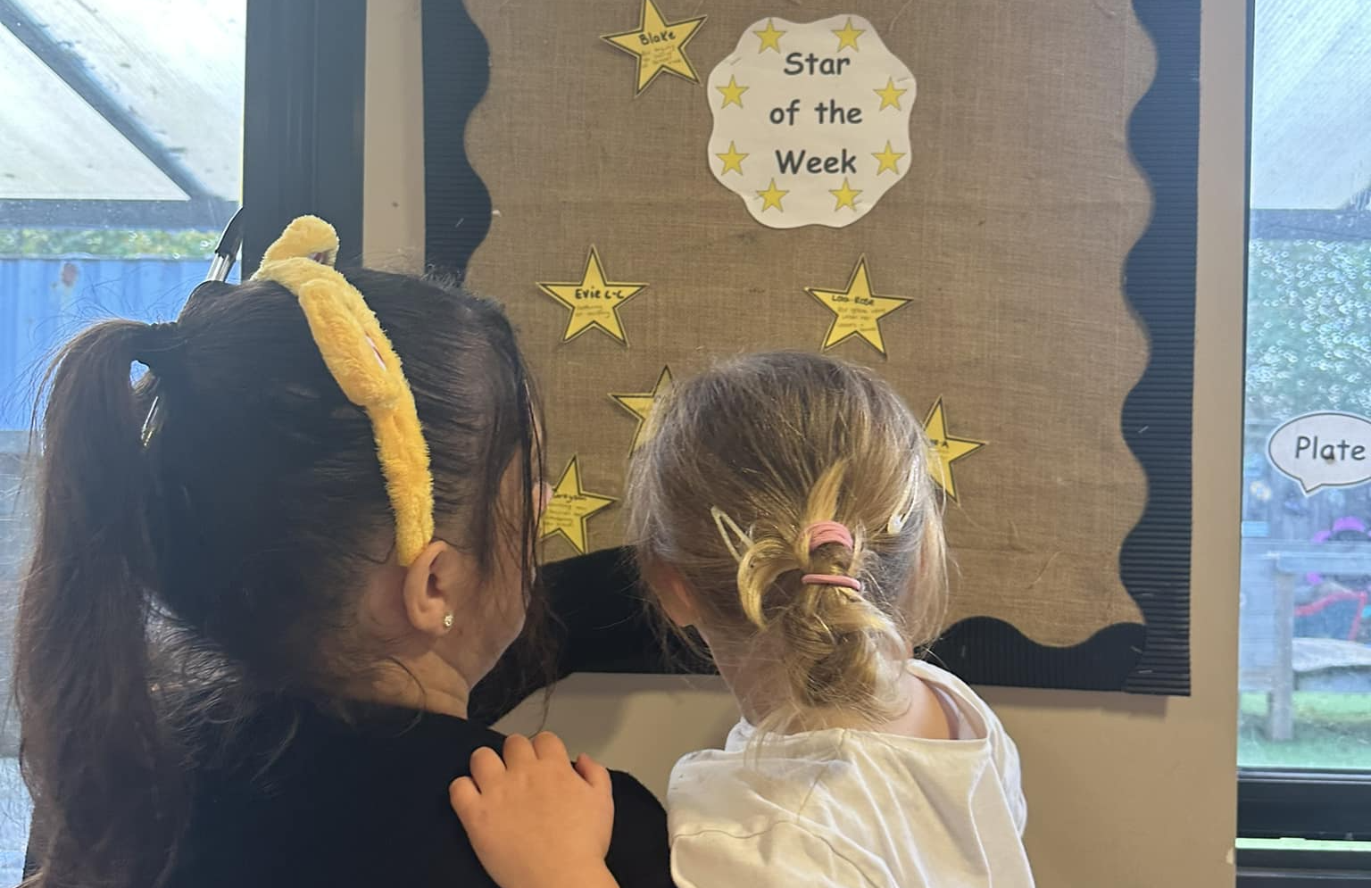 Children looking at star of the week board