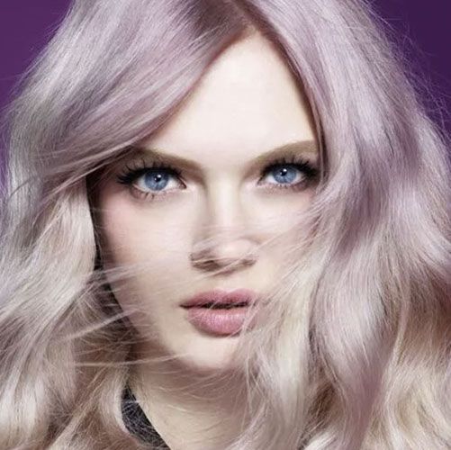 Woman with light purple hair and blue eyes, looking towards the camera.