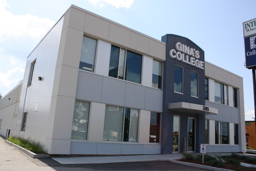 Gina's College building, light blue and white facade. Grey entrance with sign, windows, and signpost.