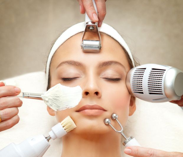 Woman receiving facial spa treatment with multiple tools.