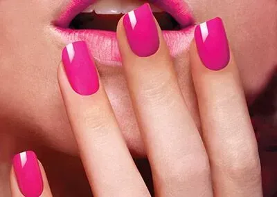 Pink fingernails against lips and open mouth, painted pink.