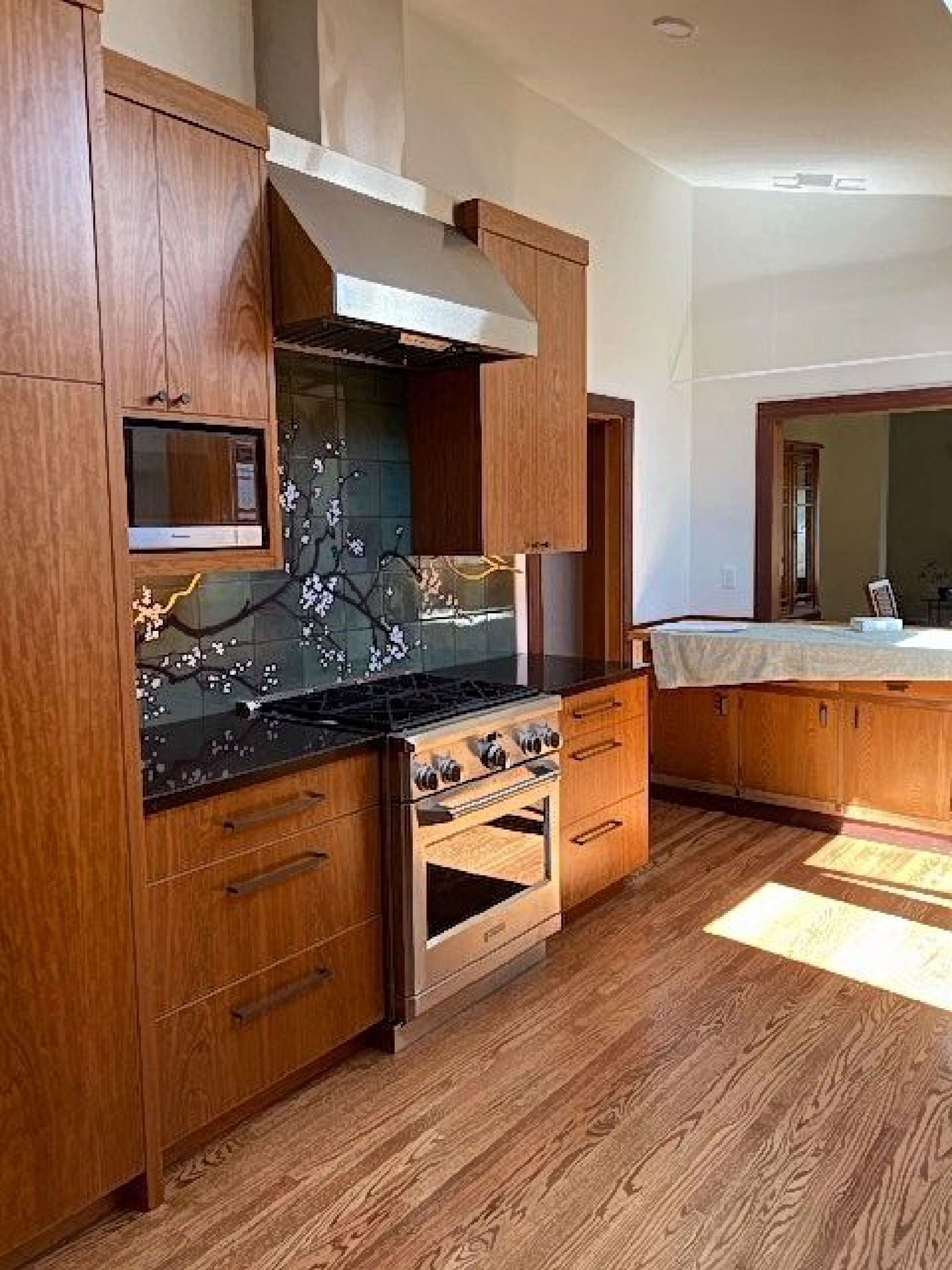 A kitchen with wooden cabinets , a stove , and a microwave.