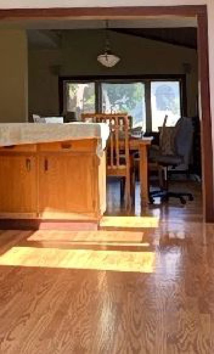 A kitchen with hardwood floors and a table and chairs.