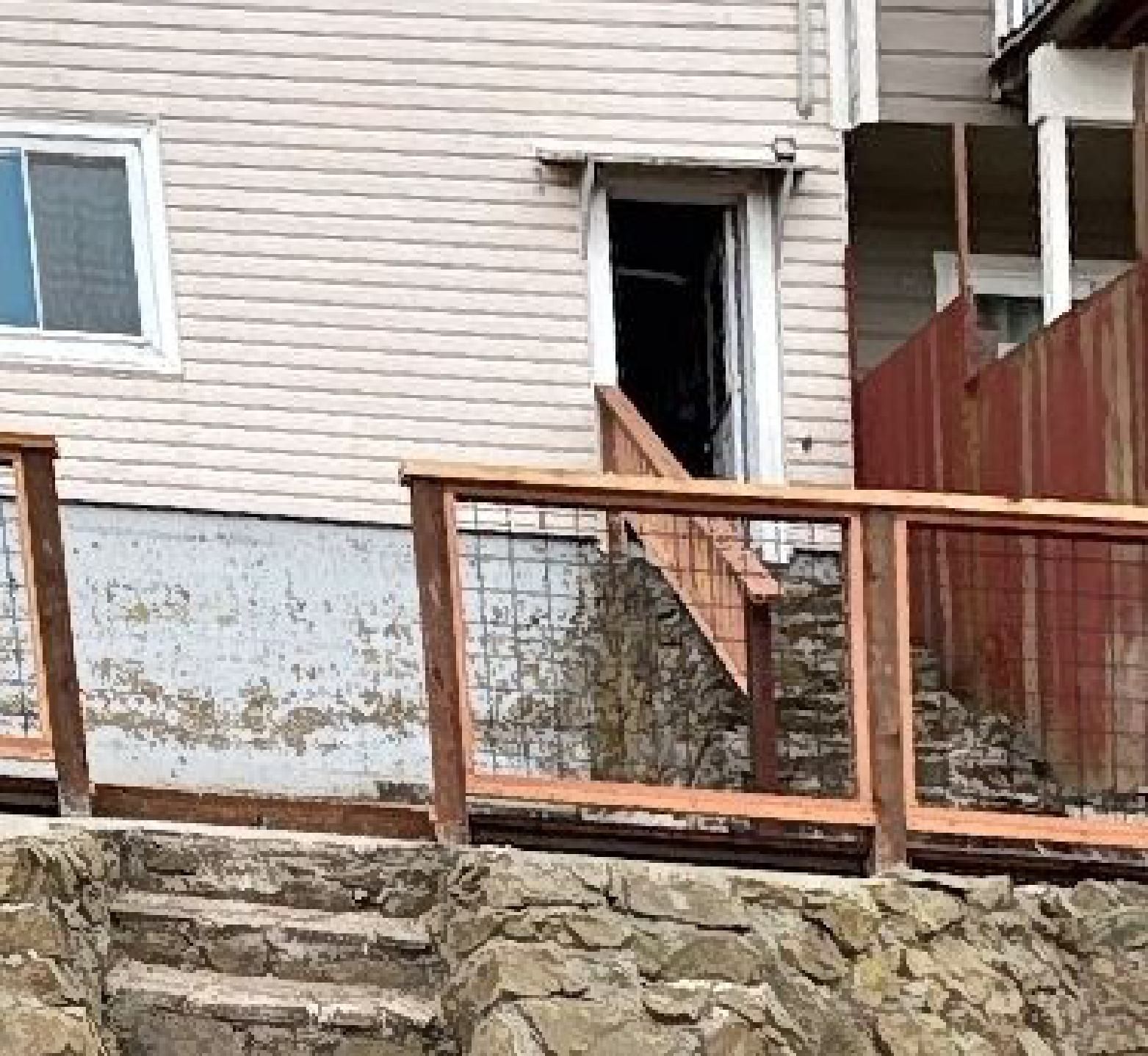 A house with stairs leading up to it and a wooden railing