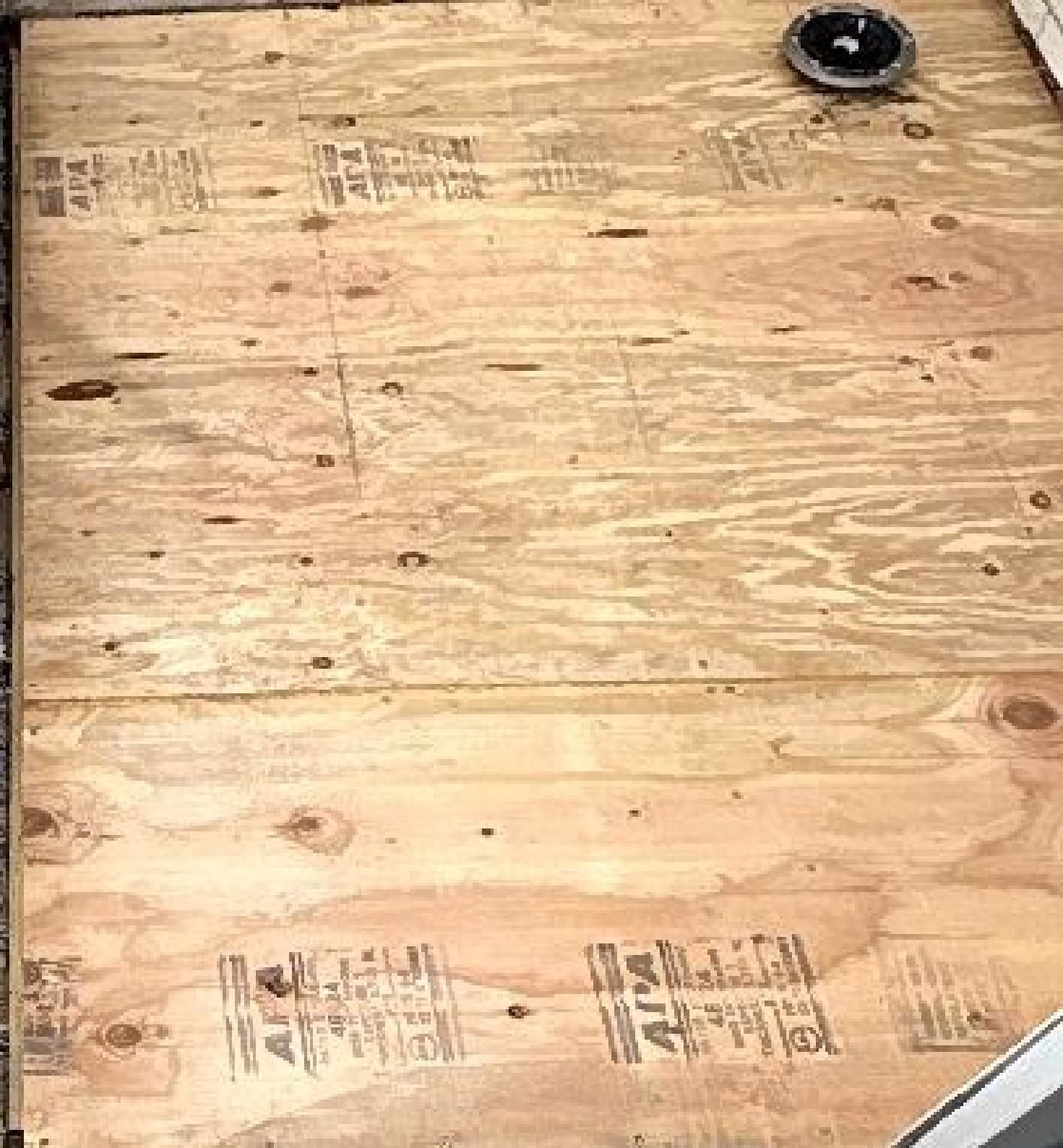 A piece of plywood is sitting on top of a wooden floor.