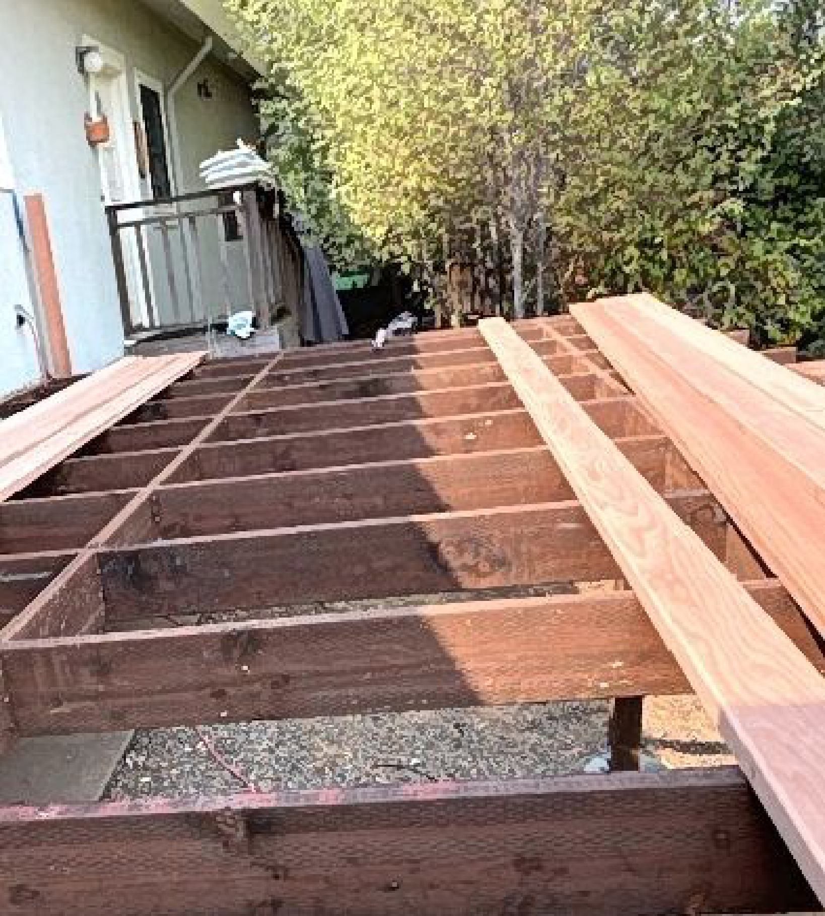A wooden deck is being built in front of a house.