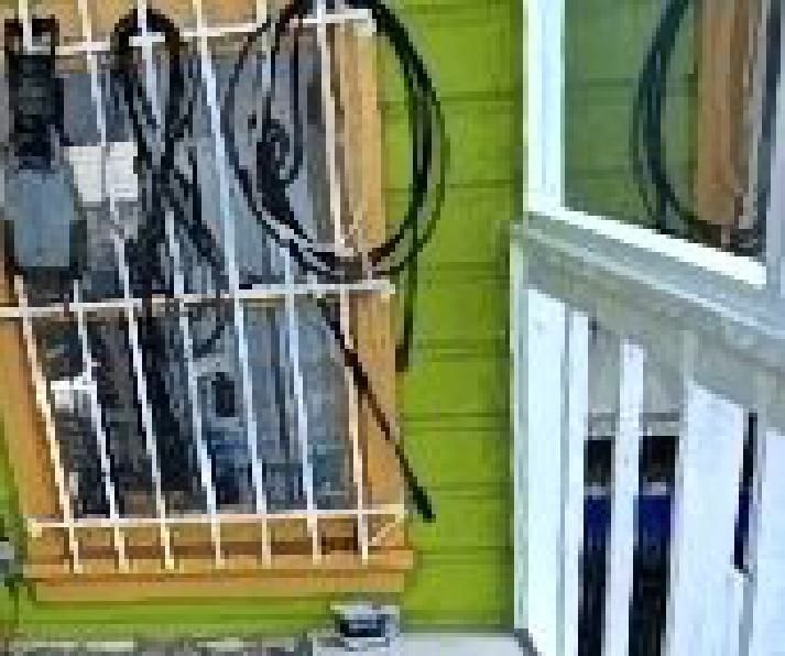 A window with a fence around it and a bunch of wires hanging from it.