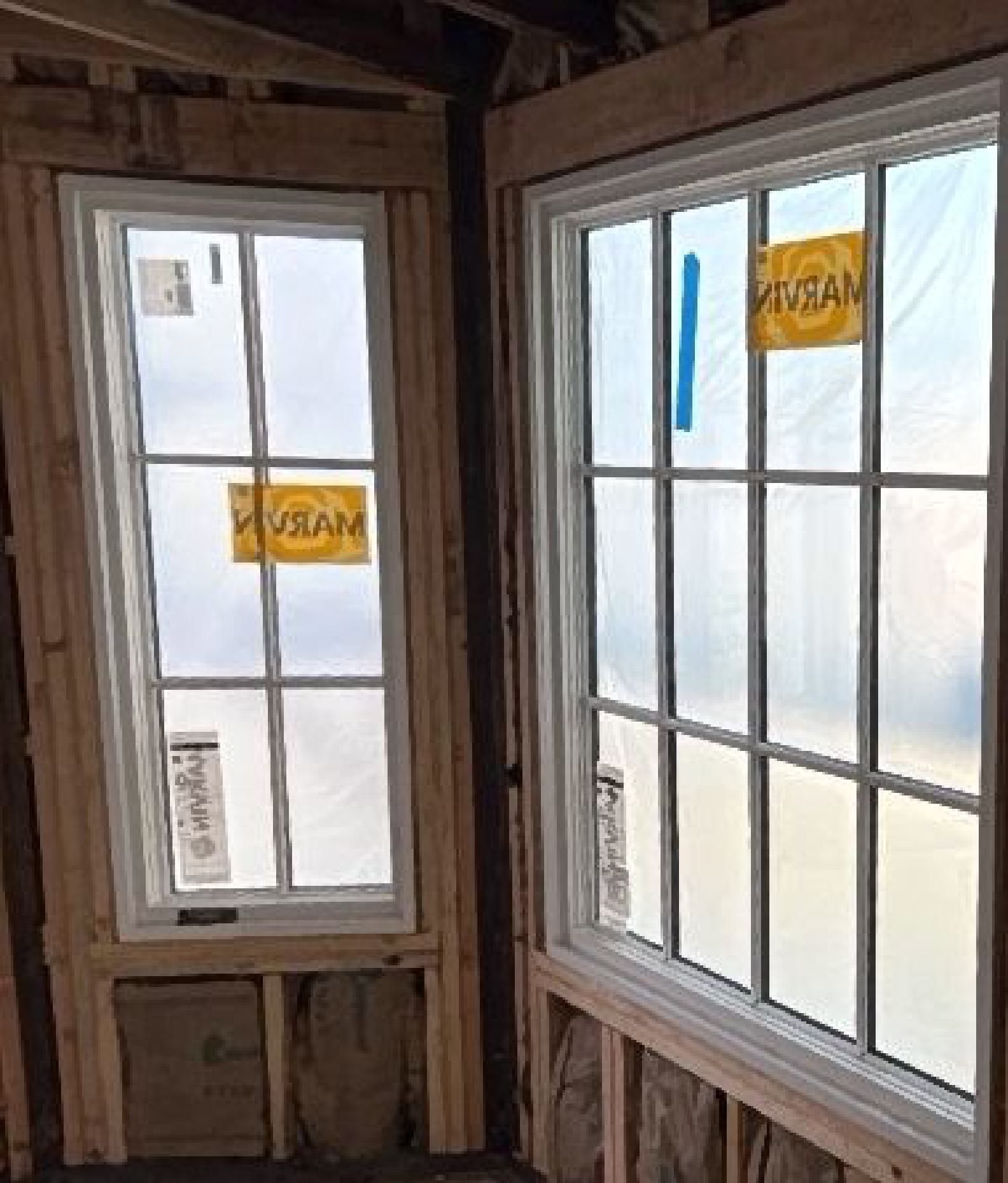 Two windows are being installed in a room with a sign that says vision