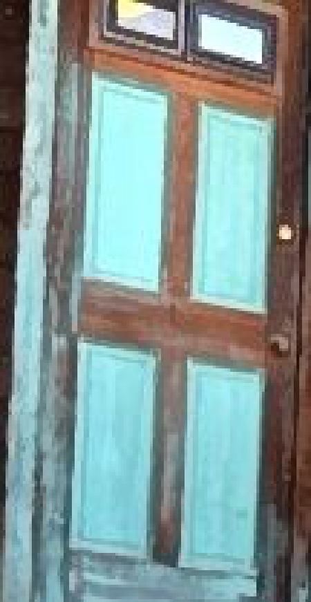 A close up of a wooden door with blue windows.