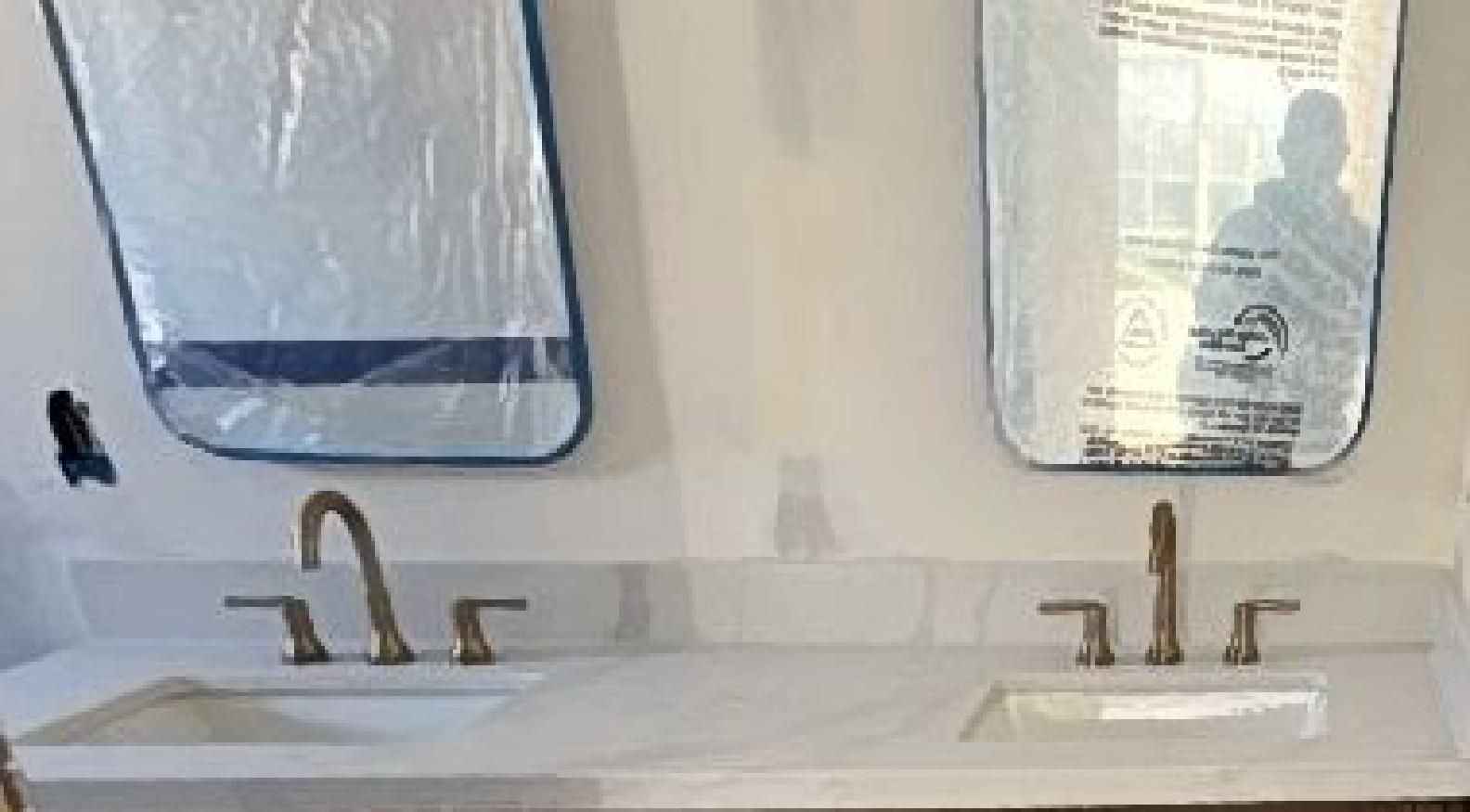 A bathroom with two sinks and two mirrors.