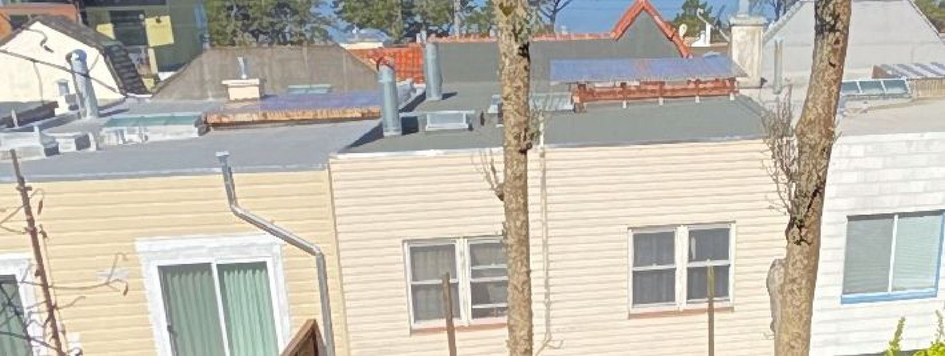A row of houses with a roof that has solar panels on it.