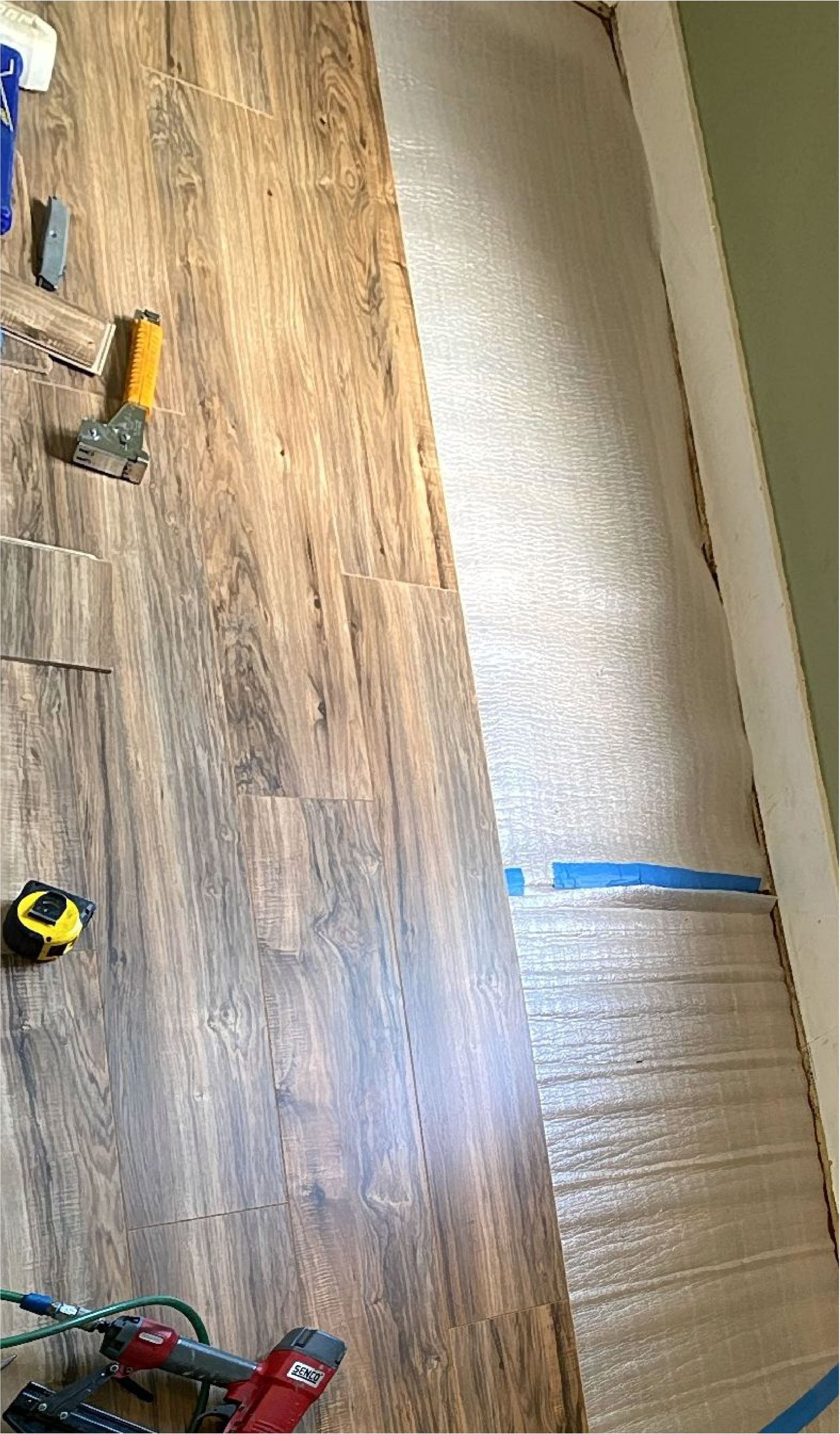 A wooden floor is being installed in a room with tools.