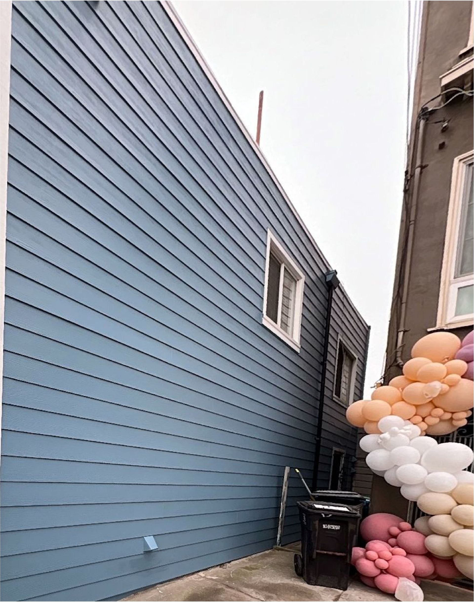 A blue building with balloons on the side of it.