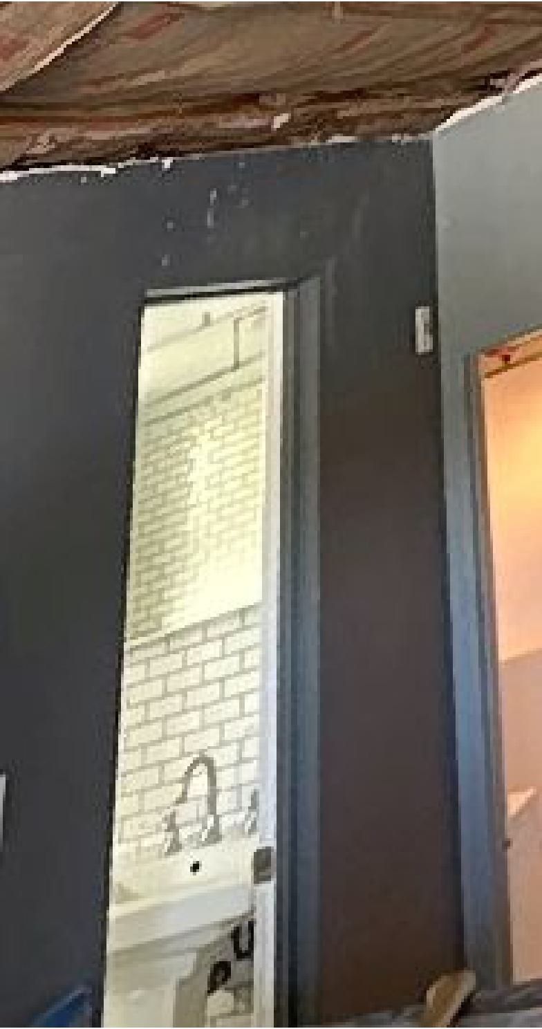 A bathroom with a sink and a door that is open.