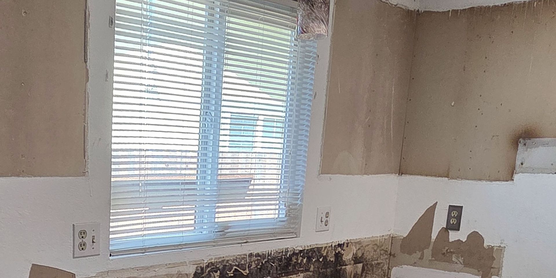 A room with a window and blinds on it.