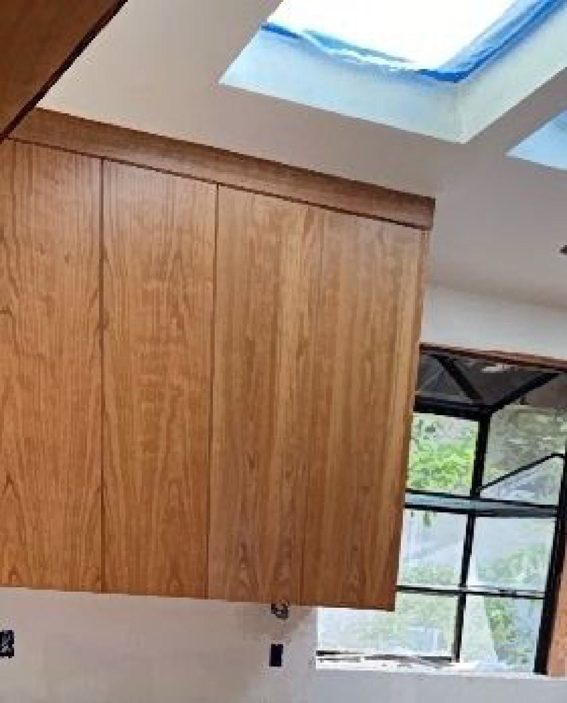 A kitchen with wooden cabinets and a skylight.