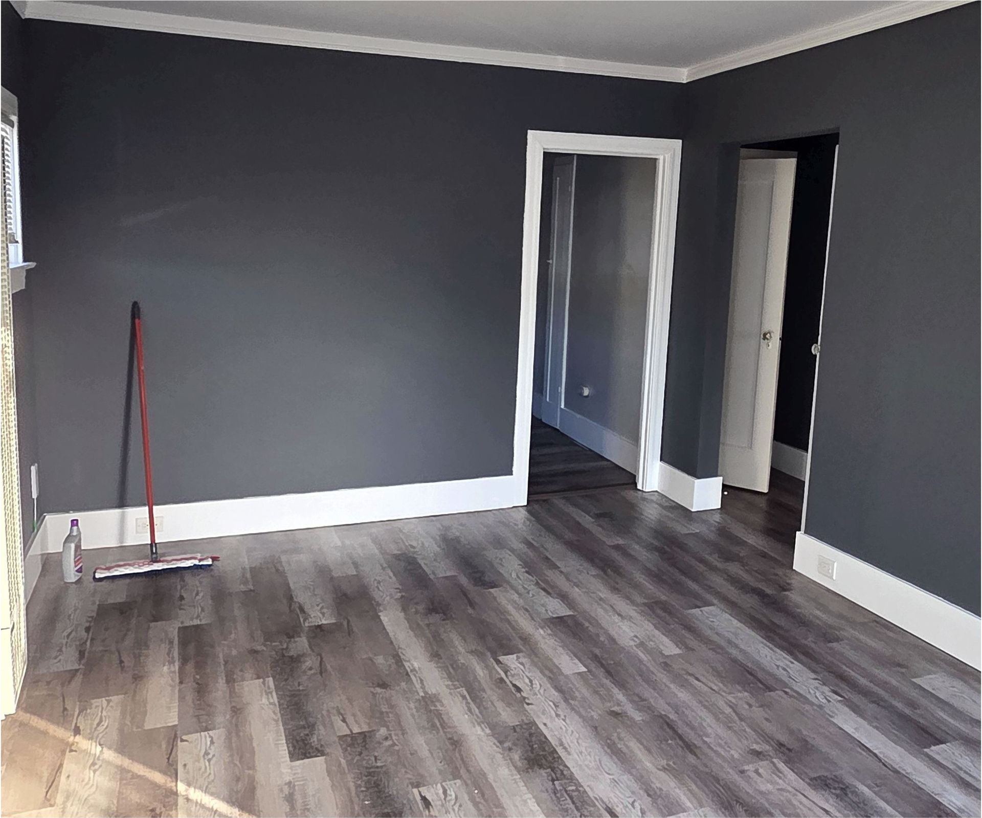 An empty room with gray walls and a wooden floor