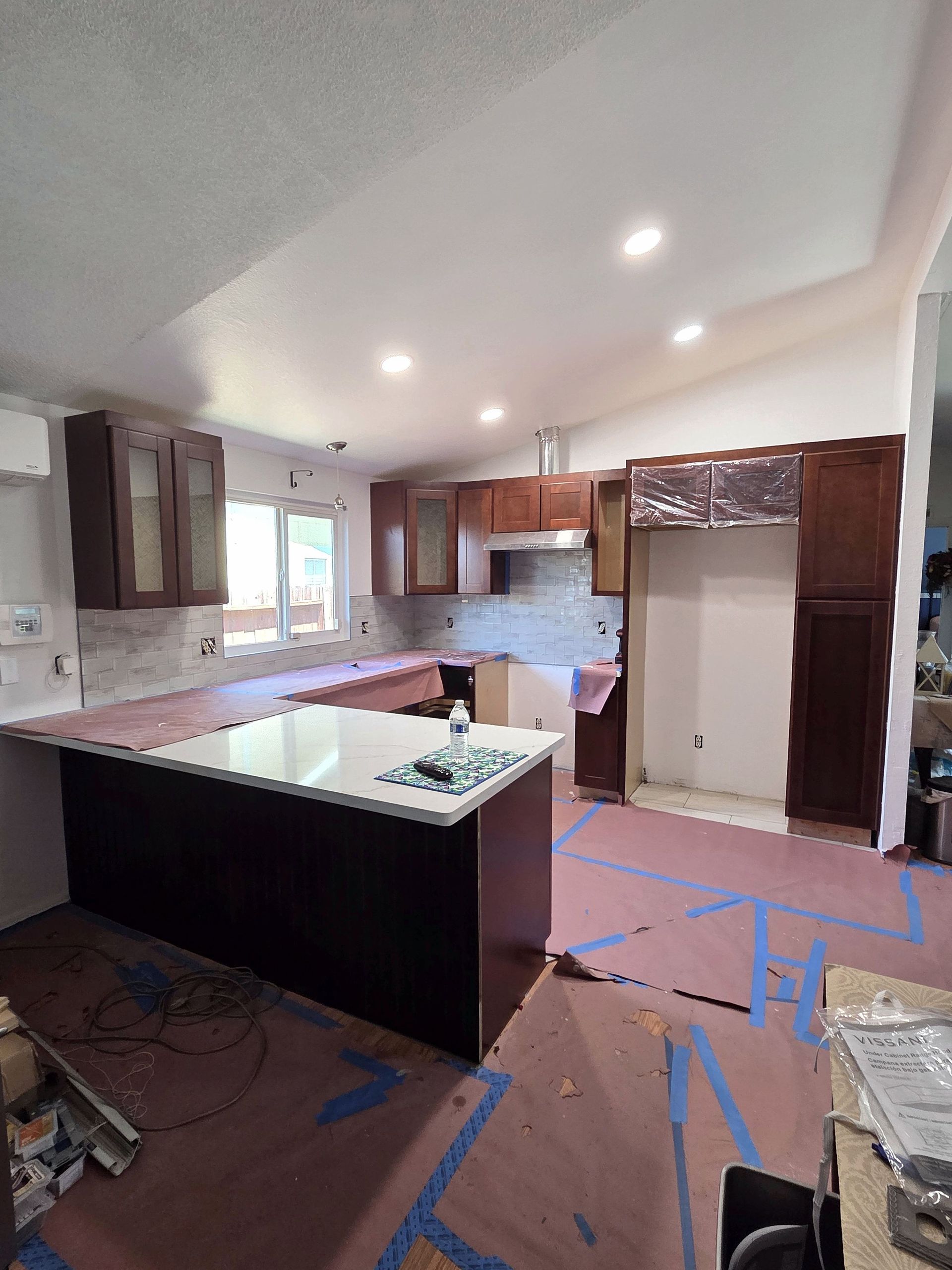 A kitchen under construction with a large island in the middle.