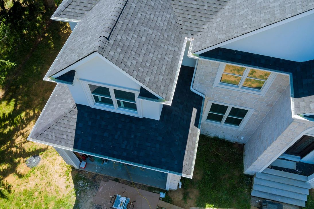 An aerial view of a large house with a gray roof.