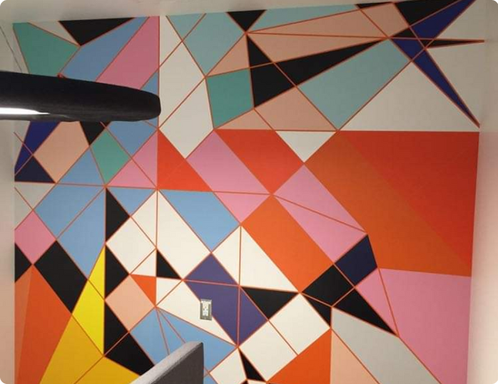 A wall with a colorful geometric pattern painted on it