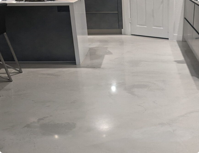 A kitchen with a white marble floor and stools.