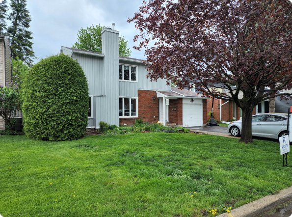 A house with a lot of grass and a car parked in front of it