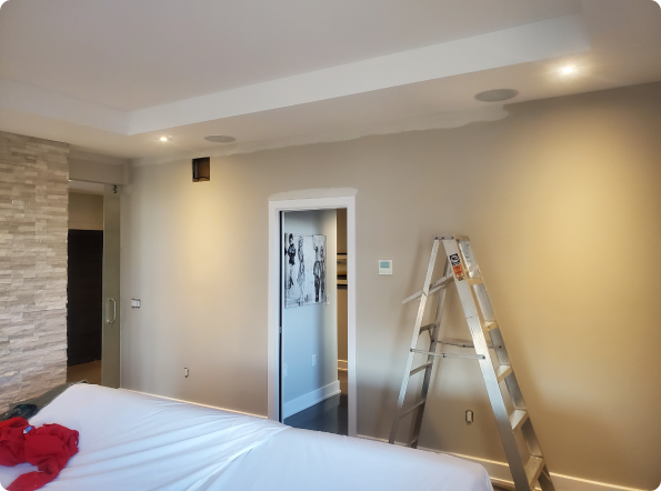 A bedroom with a bed and a ladder on the floor