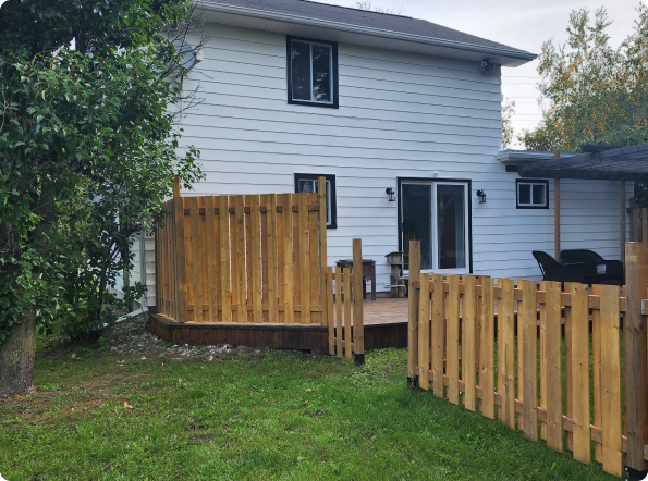 A white house with a wooden fence in front of it