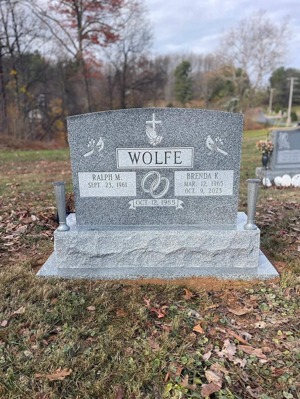 A gray granite headstone inscribed 