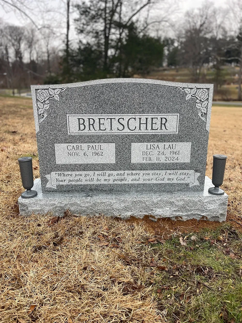 A grey granite headstone marked 