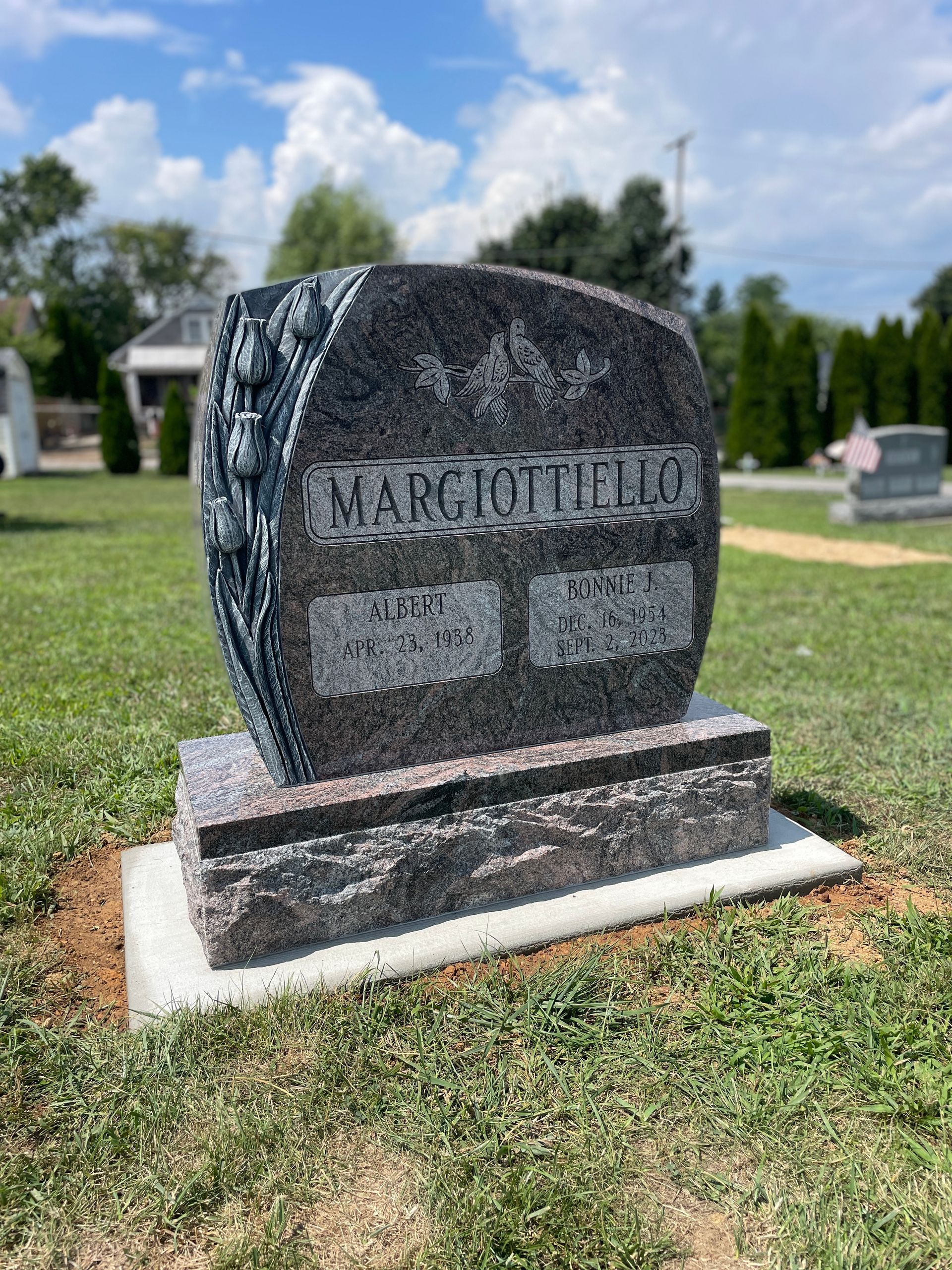 A dark granite tombstone with the name 