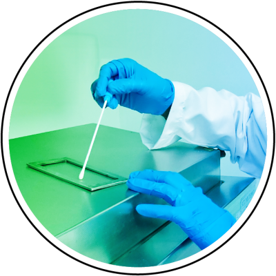 Person in blue gloves and lab coat using a swab on a stainless steel surface.