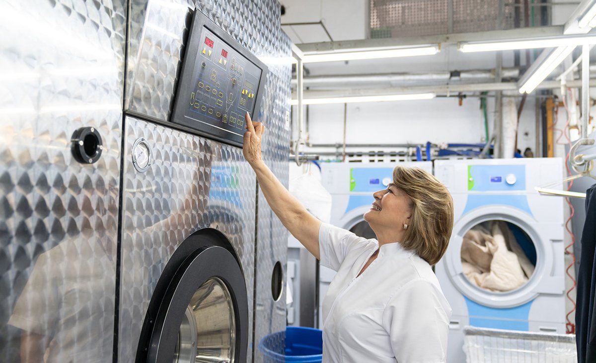Woman Setting Up The Laundry Machine — Arlington, TX — Bond Cleaners
