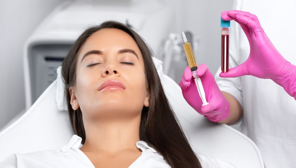 Woman receiving cosmetic treatment, doctor holding syringe and blood vial.
