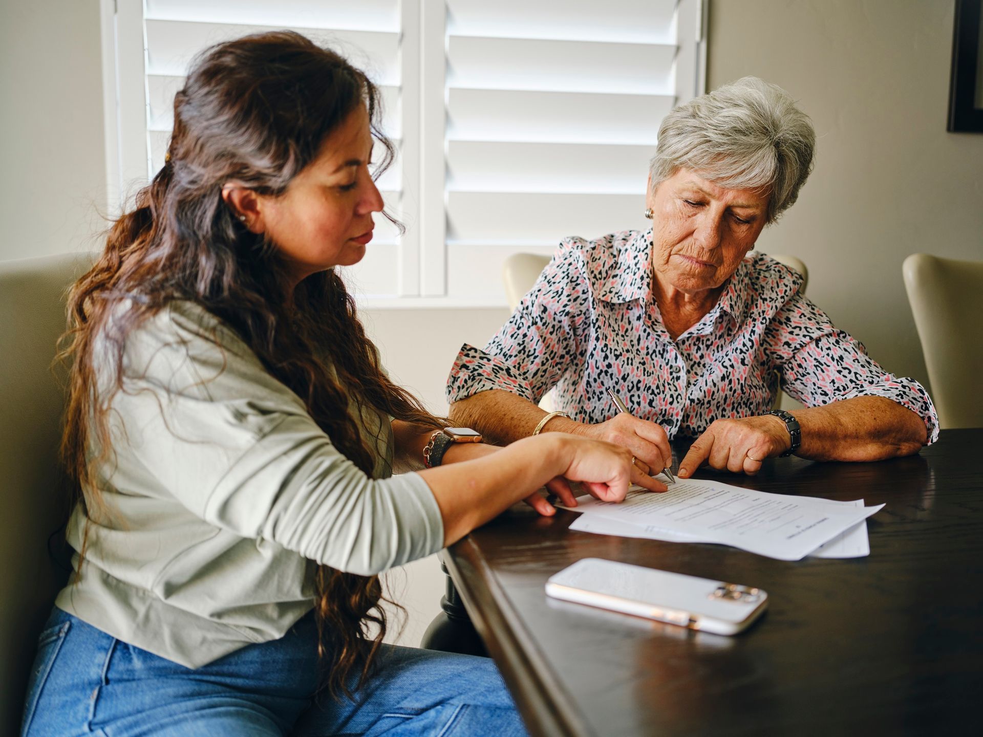 Two Women Are Sitting At A Table Looking At A Piece Of Paper | Columbus, MS | Dunn & Hemphill, P.A.