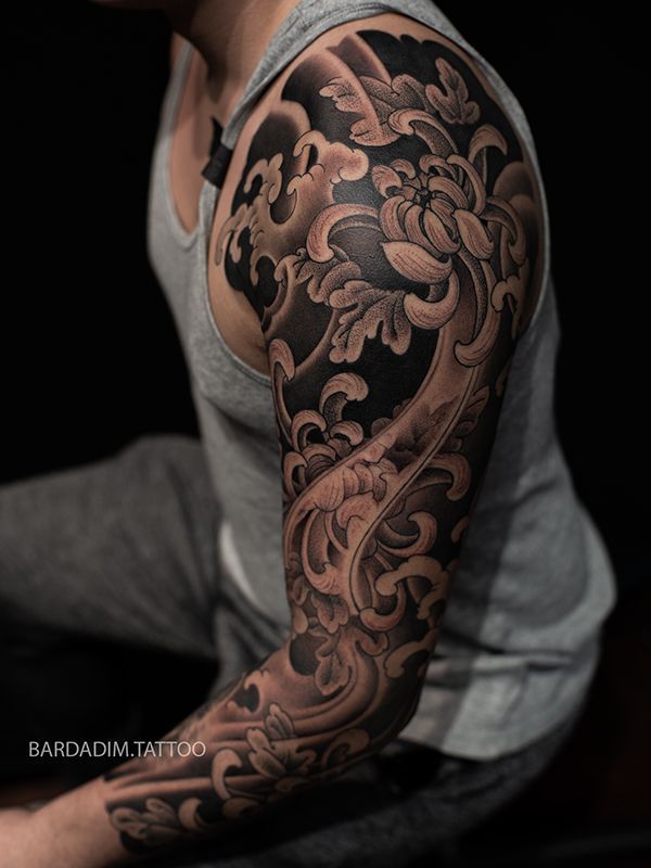A man has a full sleeve tattoo on his arm.