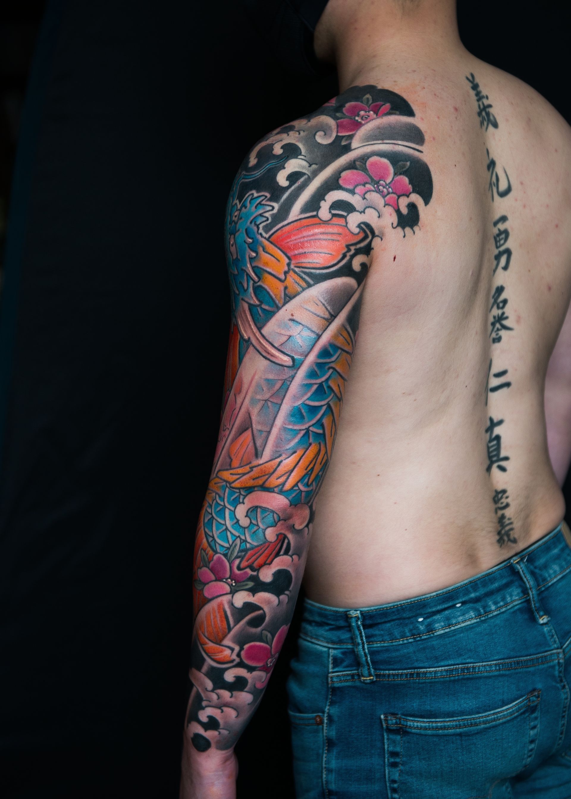 A man with a tattoo on his arm and back.