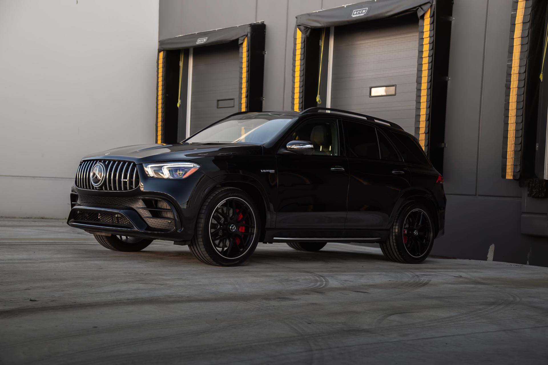 A black suv is parked in front of a building.