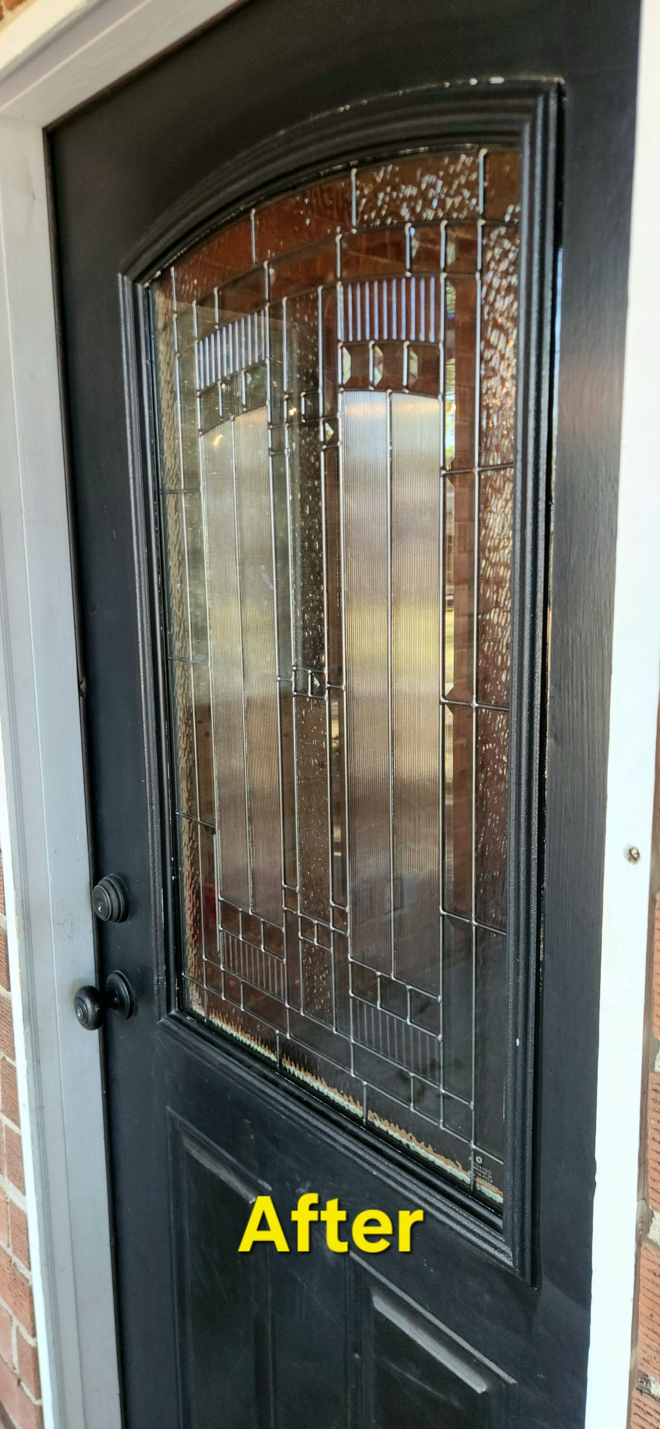 Black front door with decorative glass panel, showing "After" a renovation.